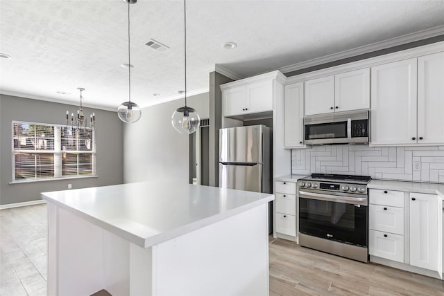 kitchen with a center island, white cabinets, decorative backsplash, decorative light fixtures, and stainless steel appliances