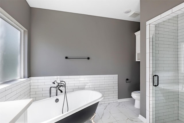 bathroom featuring separate shower and tub and toilet