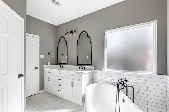 bathroom featuring a washtub, tile walls, and vanity