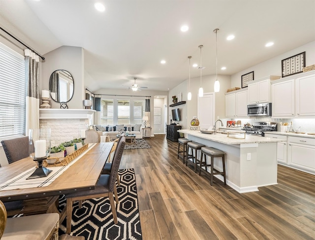 dining room featuring dark hardwood / wood-style floors, vaulted ceiling, and ceiling fan