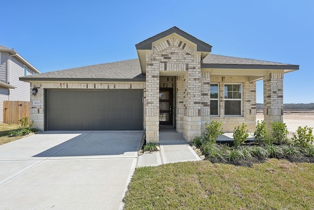 view of front of property with a shingled roof, concrete driveway, an attached garage, a front yard, and stone siding