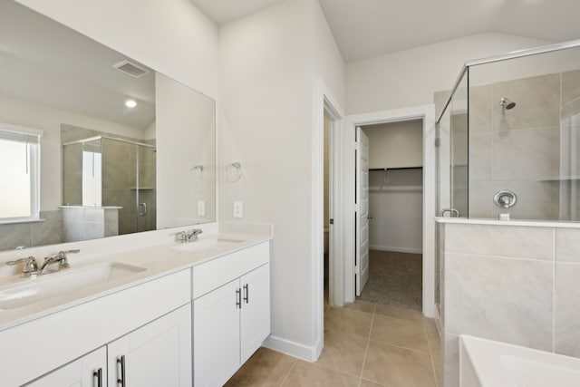 full bathroom with visible vents, a sink, a spacious closet, and a shower stall