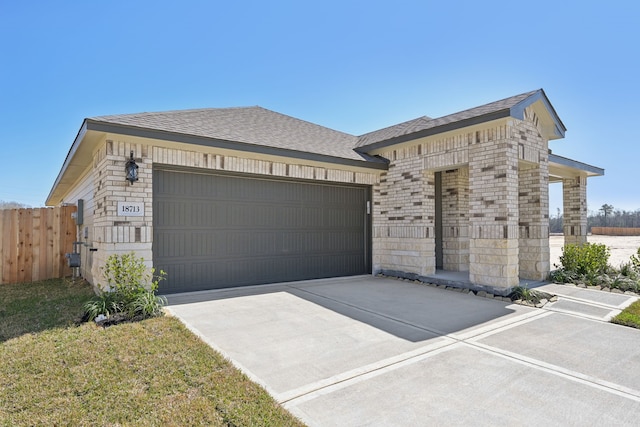 view of front of home with an attached garage, brick siding, fence, concrete driveway, and roof with shingles