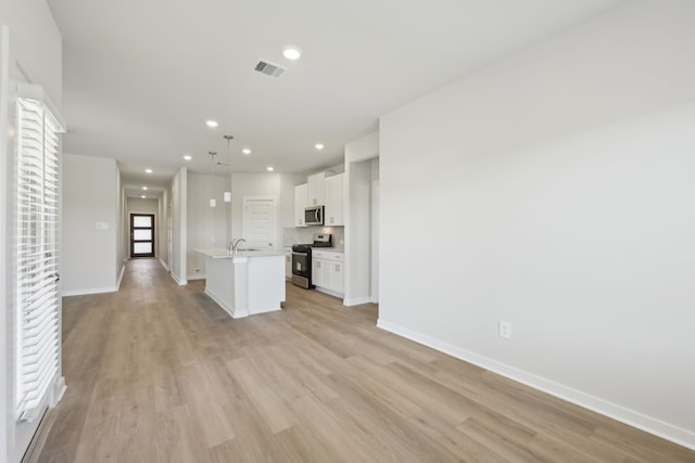 unfurnished living room with baseboards, recessed lighting, visible vents, and light wood-style floors