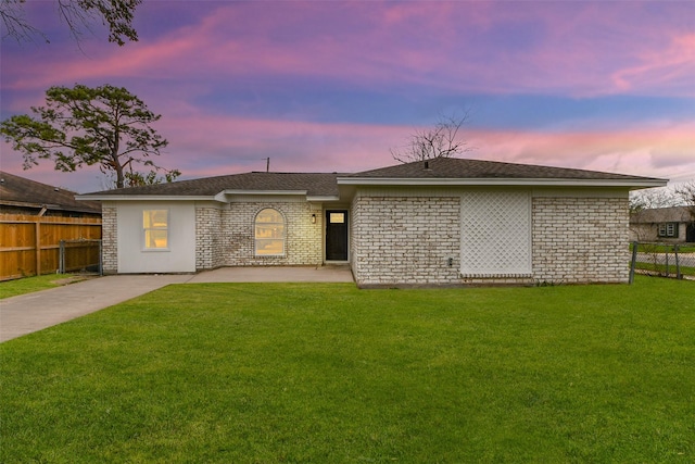 back house at dusk with a lawn