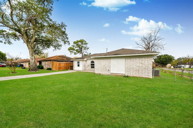 rear view of property featuring central AC and a yard