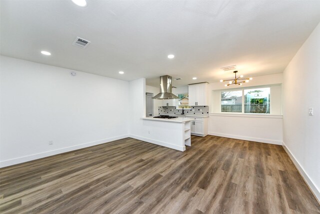 unfurnished living room with an inviting chandelier and dark wood-type flooring