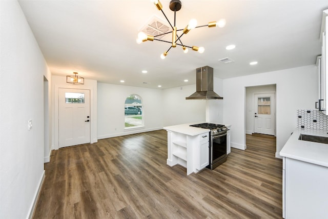 kitchen featuring gas range, island range hood, dark hardwood / wood-style floors, and a chandelier