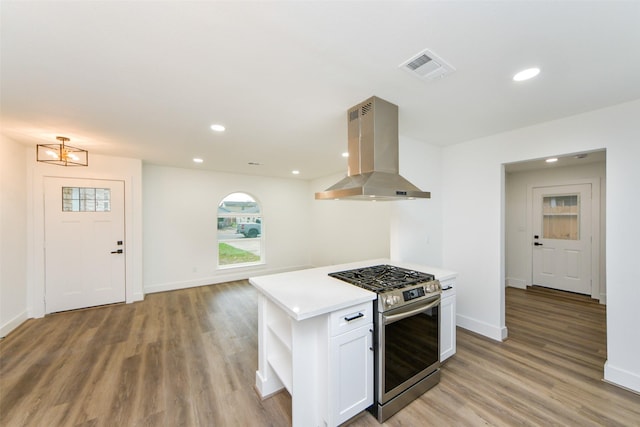 kitchen featuring stainless steel gas range, a center island, white cabinets, island exhaust hood, and light wood-type flooring