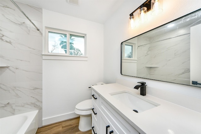 full bathroom featuring tiled shower / bath, vanity, toilet, and hardwood / wood-style floors