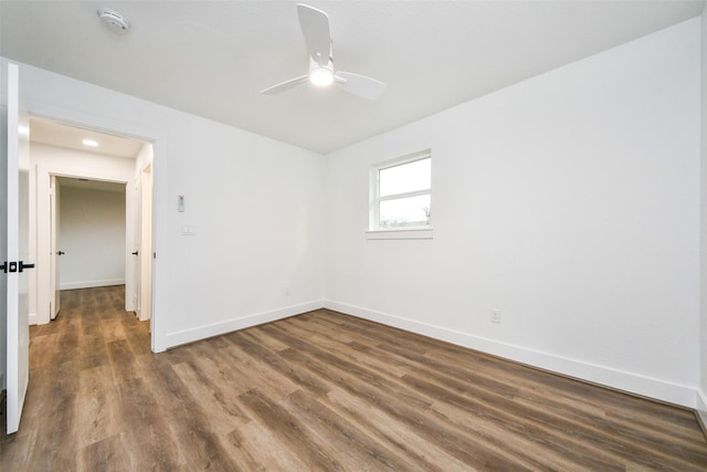 empty room with dark hardwood / wood-style flooring and ceiling fan