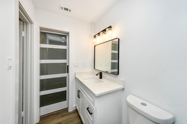 bathroom featuring hardwood / wood-style flooring, vanity, and toilet