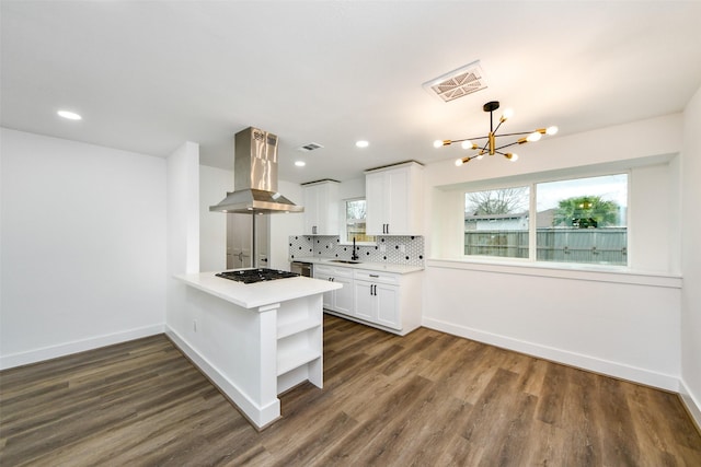 kitchen with sink, white cabinets, island exhaust hood, decorative backsplash, and kitchen peninsula