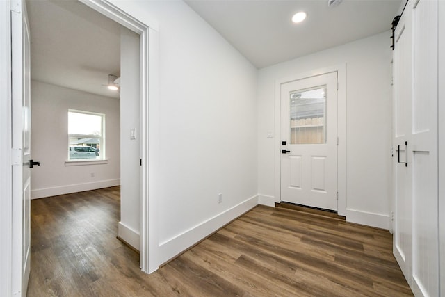 entrance foyer with a barn door and dark hardwood / wood-style flooring