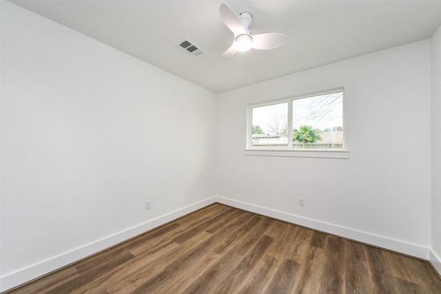 spare room with dark hardwood / wood-style flooring and ceiling fan