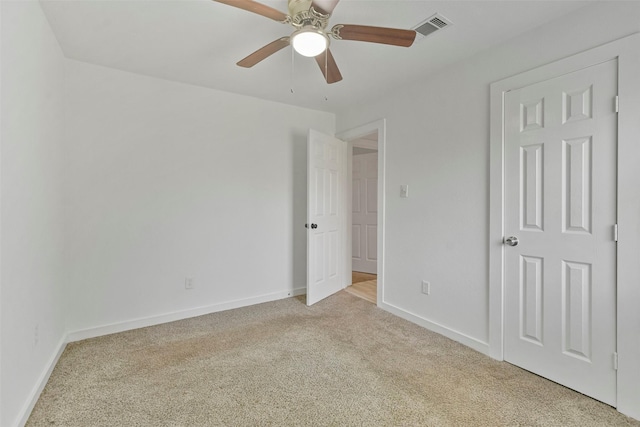 unfurnished room with light colored carpet and ceiling fan