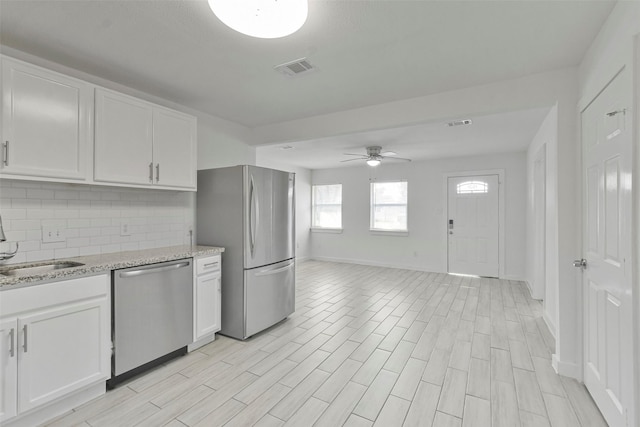 kitchen featuring white cabinets, ceiling fan, backsplash, and appliances with stainless steel finishes