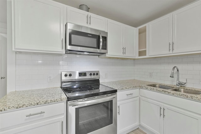 kitchen featuring backsplash, white cabinetry, sink, and appliances with stainless steel finishes