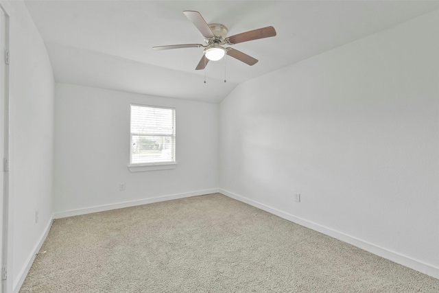 carpeted empty room with vaulted ceiling and ceiling fan