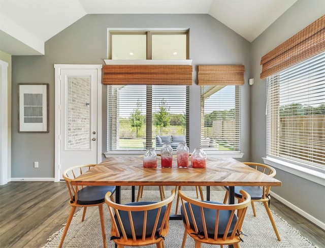 dining area with wood-type flooring and vaulted ceiling