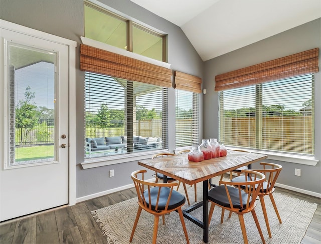 dining room with hardwood / wood-style floors and vaulted ceiling