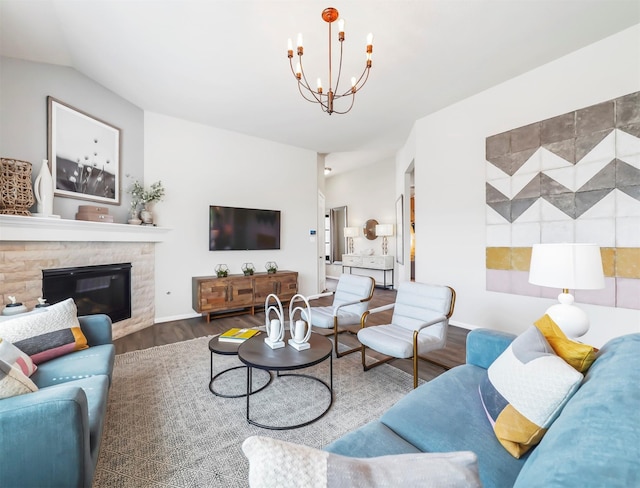 living room featuring a fireplace, a chandelier, vaulted ceiling, and hardwood / wood-style flooring