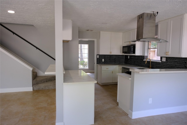 kitchen with white cabinets, dishwashing machine, kitchen peninsula, and wall chimney exhaust hood