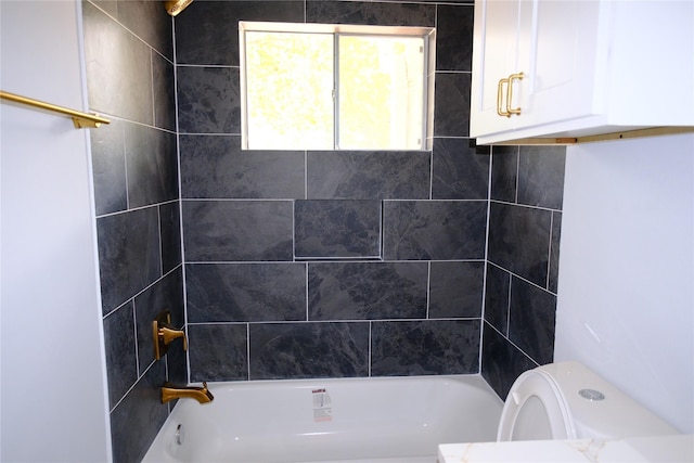 bathroom with toilet and tiled shower / bath