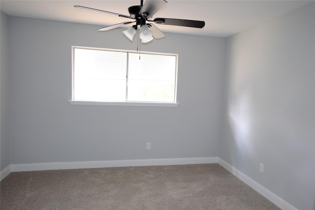 carpeted spare room featuring ceiling fan