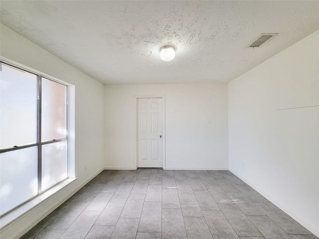 spare room with a textured ceiling