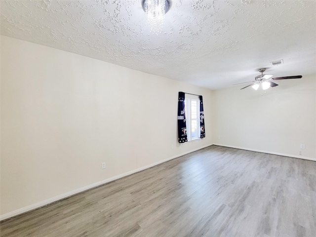 unfurnished room featuring ceiling fan, light wood-type flooring, and a textured ceiling