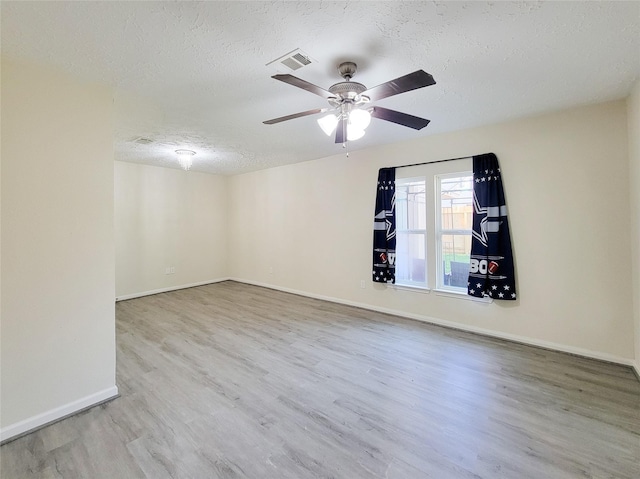 empty room with ceiling fan, light hardwood / wood-style floors, and a textured ceiling