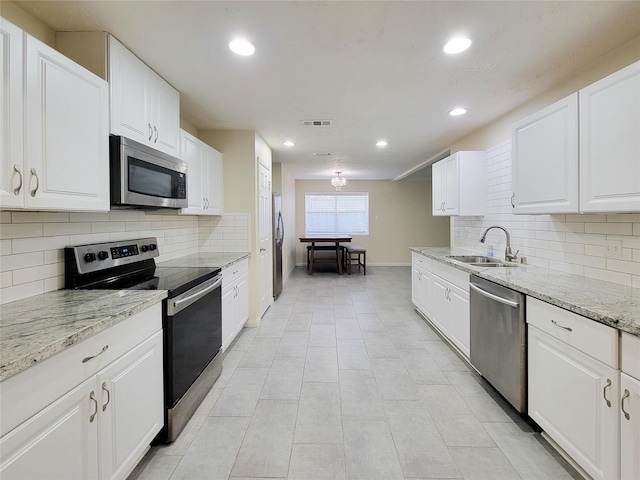 kitchen with white cabinets, light tile patterned floors, stainless steel appliances, and sink