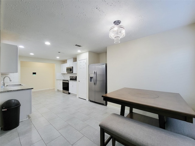 kitchen featuring white cabinets, decorative backsplash, sink, and stainless steel appliances