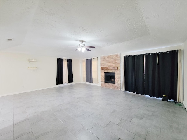 unfurnished living room featuring ceiling fan, vaulted ceiling, a textured ceiling, and a brick fireplace