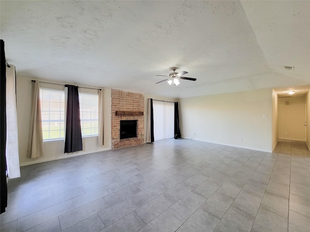 unfurnished living room featuring a textured ceiling, ceiling fan, a fireplace, and vaulted ceiling