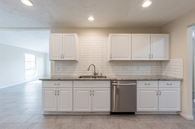 kitchen with tasteful backsplash, stainless steel dishwasher, sink, dark stone countertops, and white cabinets