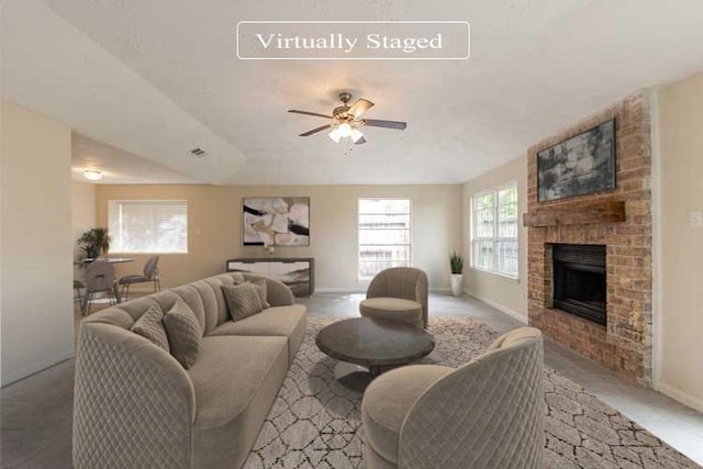 living room with ceiling fan and a fireplace