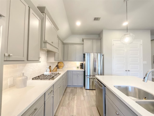 kitchen featuring tasteful backsplash, hanging light fixtures, stainless steel appliances, and sink