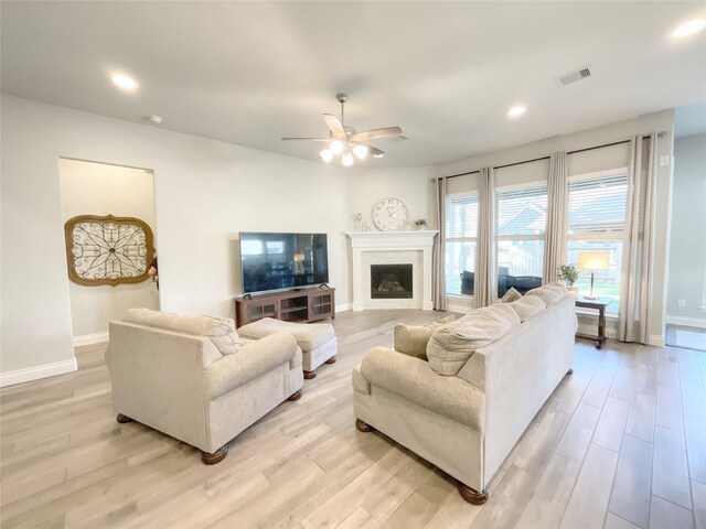 living room with light hardwood / wood-style floors and ceiling fan