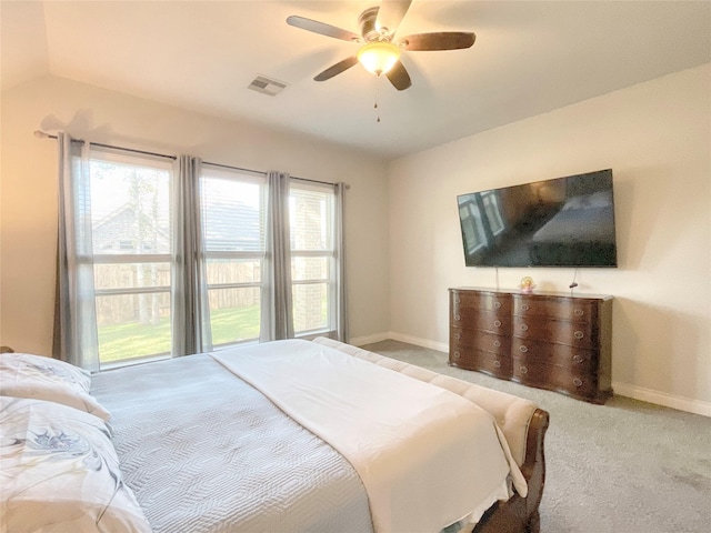 bedroom with multiple windows, light colored carpet, and ceiling fan