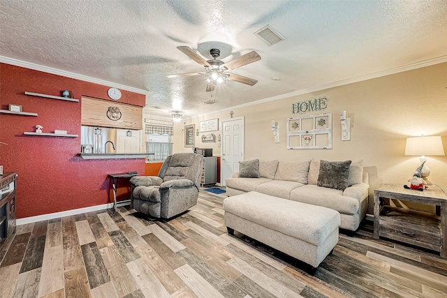 living room with a textured ceiling, hardwood / wood-style flooring, ceiling fan, and crown molding