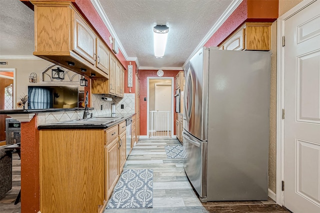 kitchen with a kitchen breakfast bar, light hardwood / wood-style flooring, kitchen peninsula, appliances with stainless steel finishes, and ornamental molding