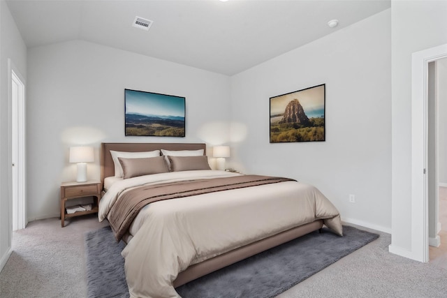 bedroom with light colored carpet and vaulted ceiling