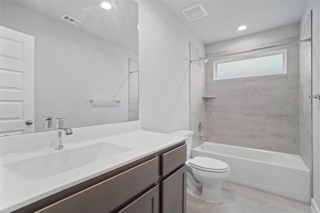 full bathroom with toilet, vanity, and tiled shower / bath