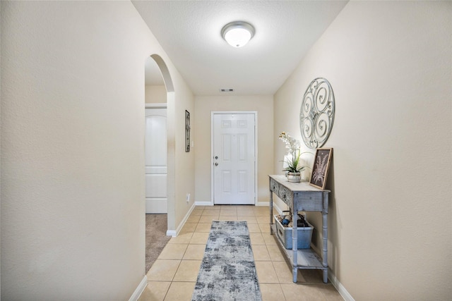 entryway with light tile patterned floors and a textured ceiling