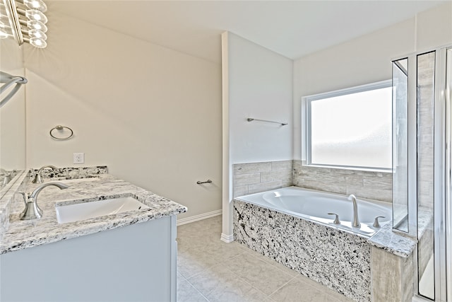 bathroom with tile patterned flooring, vanity, and tiled bath