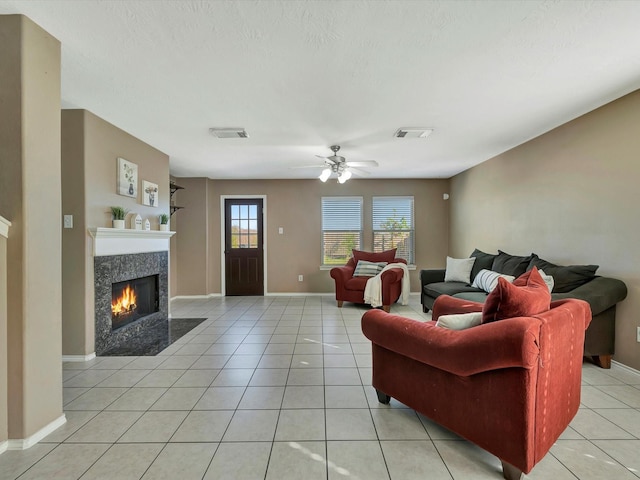 tiled living room with ceiling fan and a premium fireplace