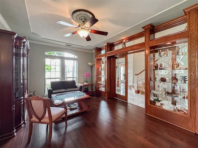 sitting room with french doors, a textured ceiling, ceiling fan, crown molding, and dark hardwood / wood-style floors