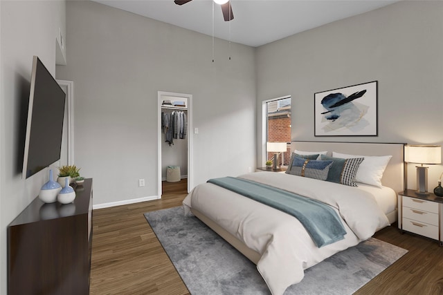 bedroom featuring a high ceiling, a closet, ceiling fan, and dark wood-type flooring